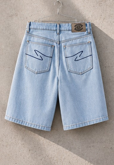 Rose Denim Jorts auf einem Kleiderbügel, Rückansicht: beide Gesäßtaschen mit geschwungener Ziernaht und Lederpatch am Bund.